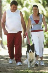 happy couple walking dog